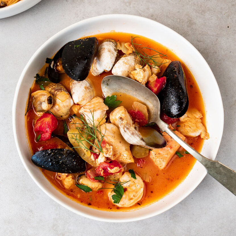 An image of prepared Seafood Cioppino made with fennel, Pacific Foods® Organic Creamy Tomato Soup, diced tomatoes, white wine, Pacific Foods® Organic Vegetable Broth, salmon, halibut or tilapia, clams, mussels and shrimp.