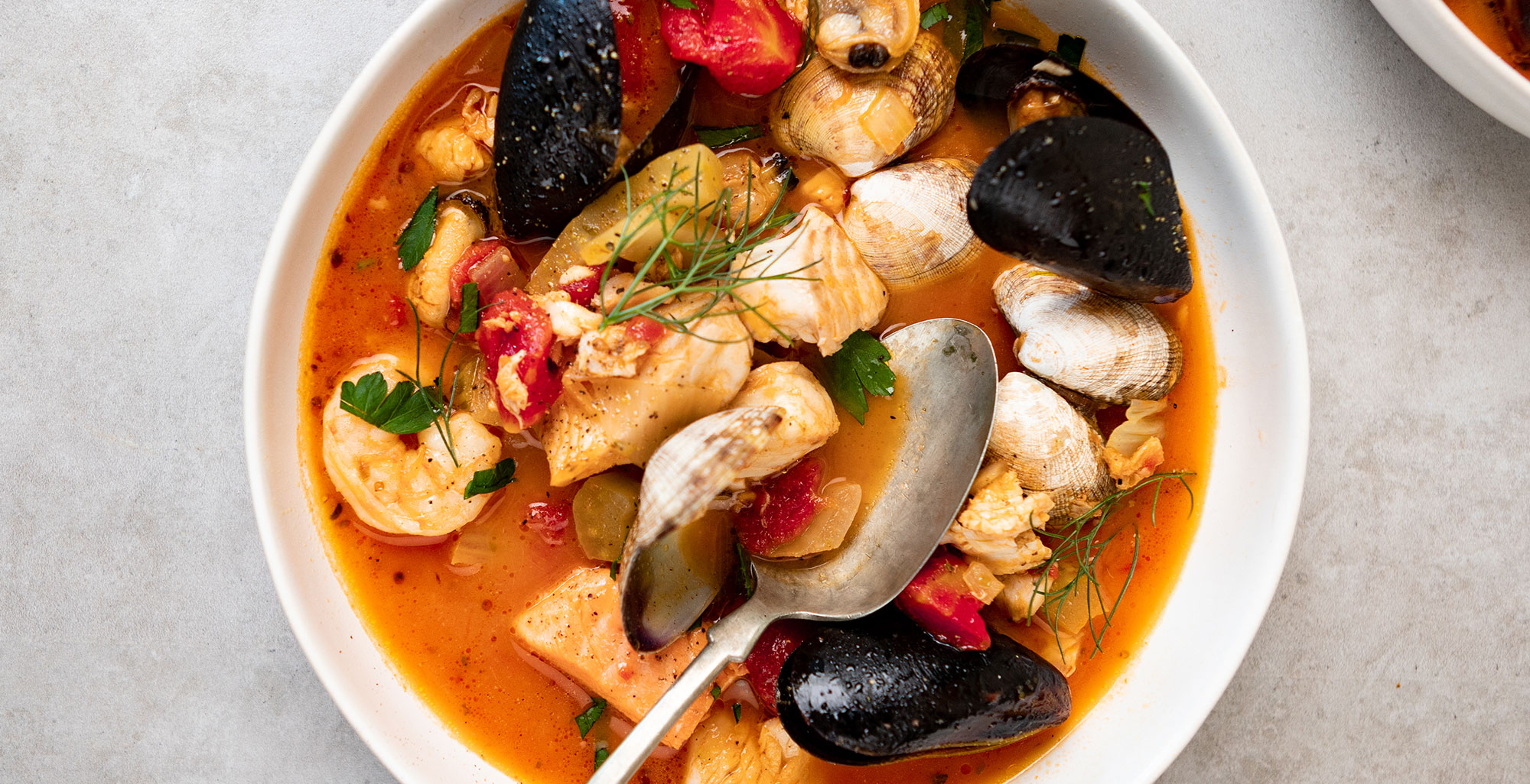 An image of prepared Seafood Cioppino made with fennel, Pacific Foods® Organic Creamy Tomato Soup, diced tomatoes, white wine, Pacific Foods® Organic Vegetable Broth, salmon, halibut or tilapia, clams, mussels and shrimp.